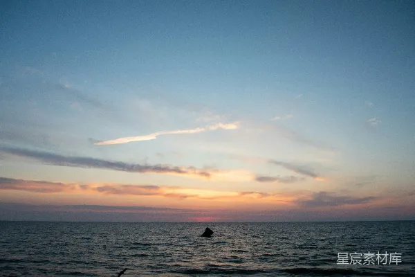 高清摄影 夕阳正投射在海面上，水中有个人。