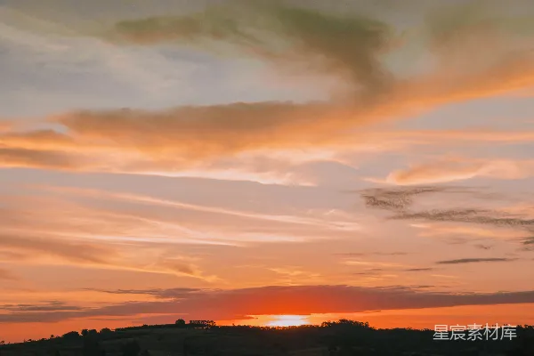 高清摄影 夕阳西下，树木环绕的田野上。