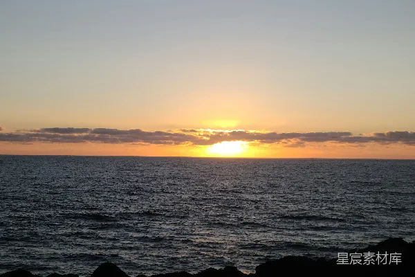 高清摄影 夕阳映照在海面上，背景是夕阳海滩。