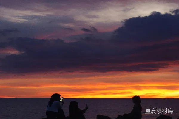 高清摄影 人们在日落时坐在岩石上。