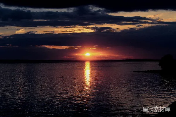 高清摄影 一片广阔的水域，背景中有一抹夕阳。