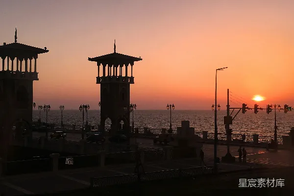 高清摄影 夕阳正照耀在海面上，前景中有一座码头。