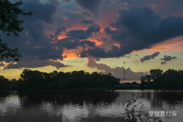 高清摄影 一片有树木和夕阳背景的水域。