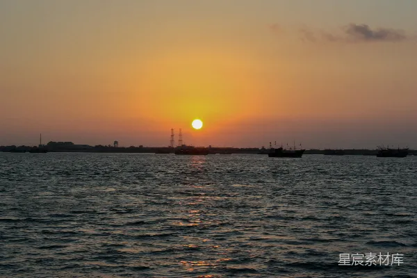 高清摄影 夕阳照耀着一片水域，远处有几艘船。