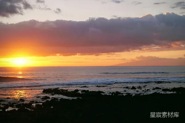高清摄影 在多云的天气里，太阳正缓缓落下，洒在海面上。