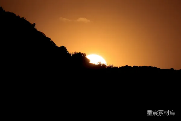 高清摄影 夕阳正在一片有树木的山坡上落下。