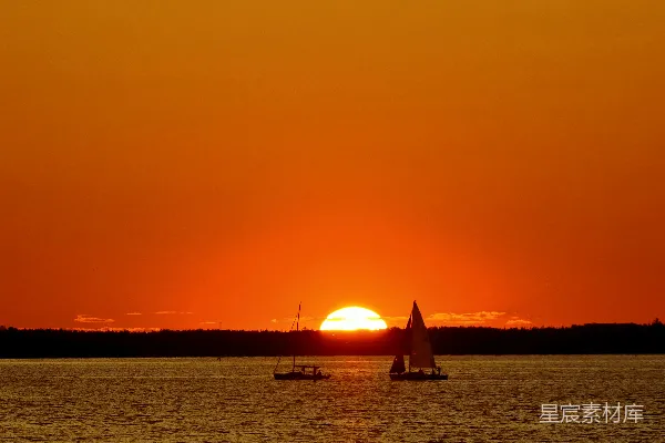 高清摄影 夕阳正缓缓落下，照耀着一片水域。
