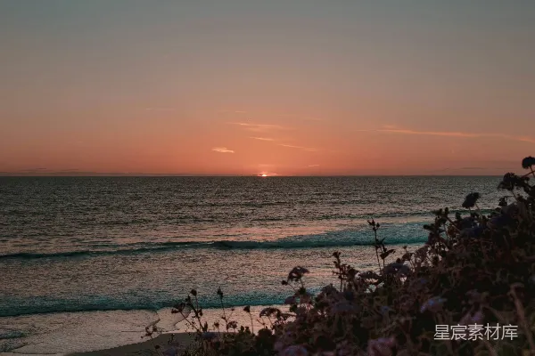 高清摄影 夕阳正挂在海洋上方的海滩上。