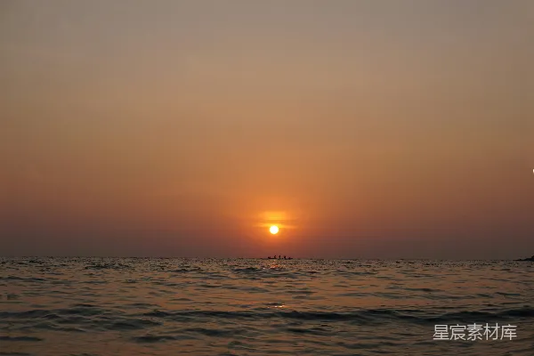 高清摄影 夕阳正挂在海面上，远处有一艘小船。