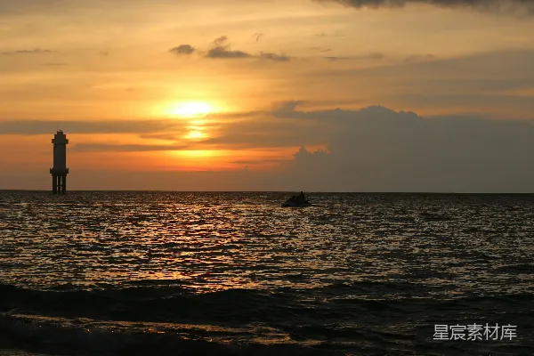 高清摄影 夕阳正挂在海平面上，一艘船静静地漂浮在水面上。