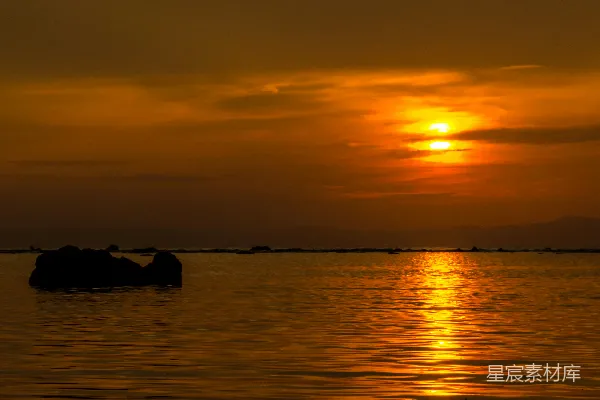 高清摄影 一片广阔的水域，背景中有夕阳。