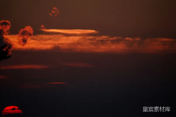 高清摄影 夕阳在天边的云朵后面落下。