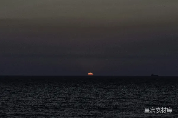 高清摄影 夕阳沉落在一片宁静而漆黑的海洋上。