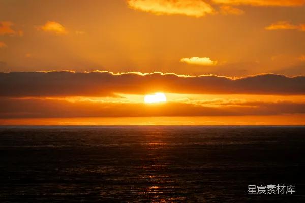 高清摄影 夕阳沉落在一片幽暗而平静的海洋上。