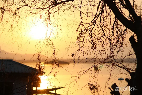 高清摄影 夕阳正落下，映照着一片水面。