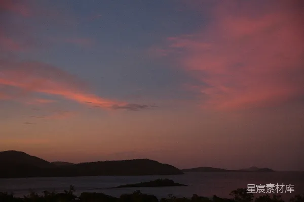 高清摄影 夕阳映照在水面上，背景是连绵的山脉。