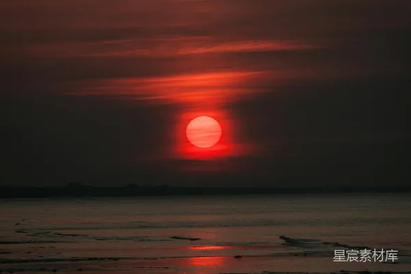 高清摄影 在多云的日子里，太阳正在海洋上落下。