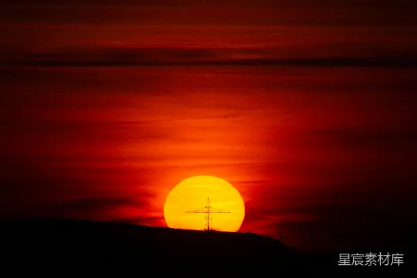 高清摄影 夕阳西下，山丘前有一座十字架。