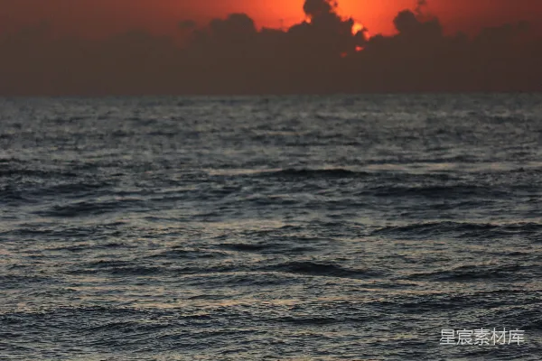 高清摄影 夕阳正在海洋上落下，水面上有一艘小船。