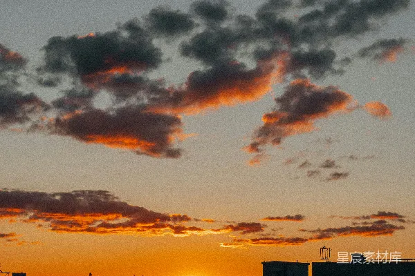 高清摄影 夕阳西下，城市上空布满橙色和深色的云朵。