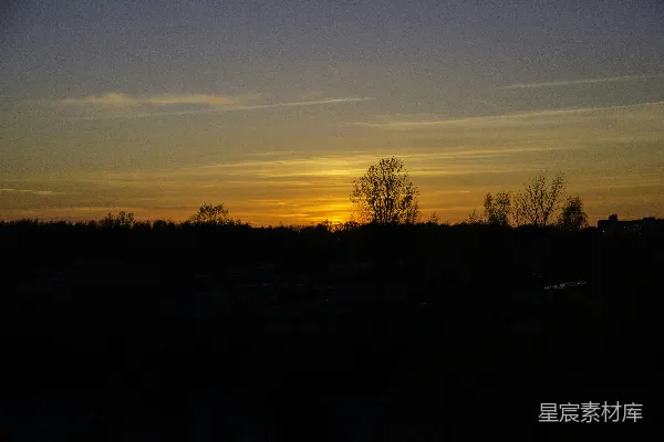 高清摄影 夕阳西下，远处的树木被夕阳染红。
