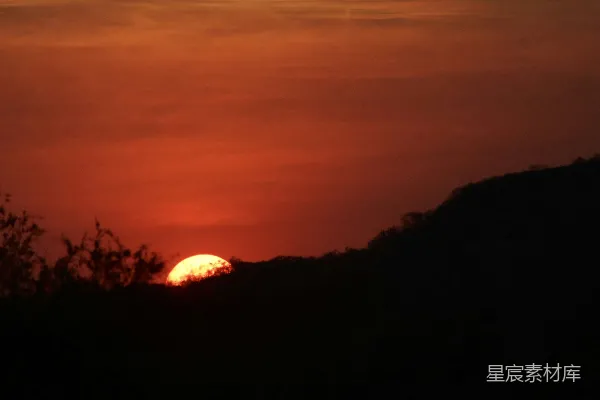 高清摄影 夕阳正在树林覆盖的山丘上落下。