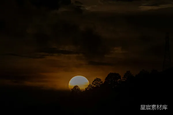 高清摄影 夕阳在树木后面，背景是戏剧性的云层