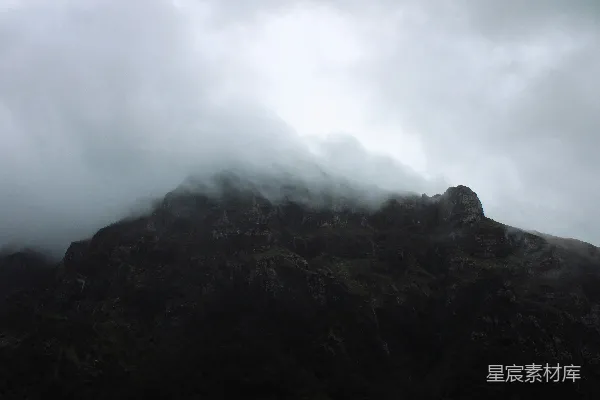 高清摄影 一座非常高的山，天空中布满了云层。