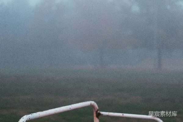 高清摄影 一个足球门在雾中，背景是树木。