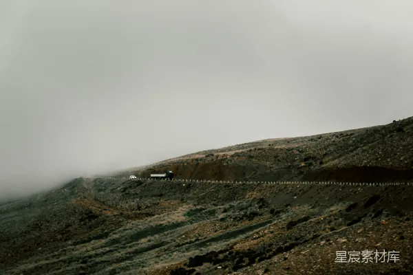 高清摄影 一座被泥土和草地覆盖的小山，在多云的天空下