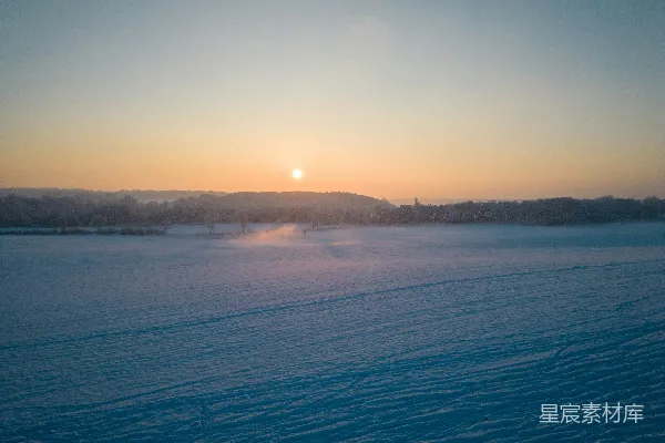 高清摄影 夕阳正在白雪覆盖的田野上落下。