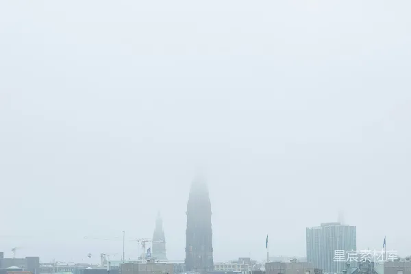高清摄影 一座城市的雾中景色，远处可见一座钟楼。
