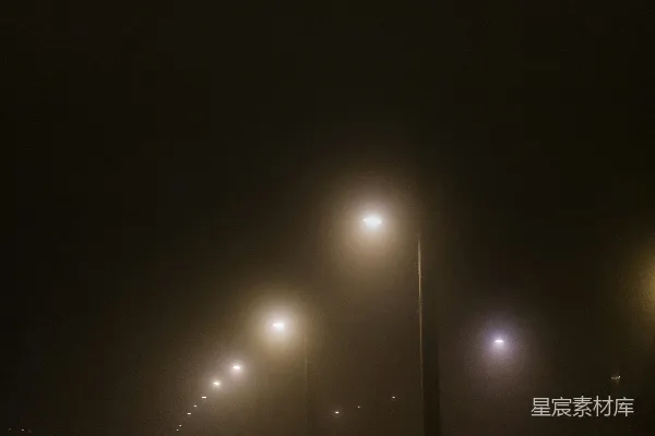 高清摄影 雾蒙蒙的街道上有街灯，在一个雾蒙蒙的夜晚。