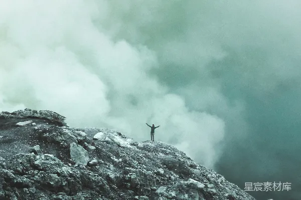 高清摄影 站在悬崖边的人，背景是云层。