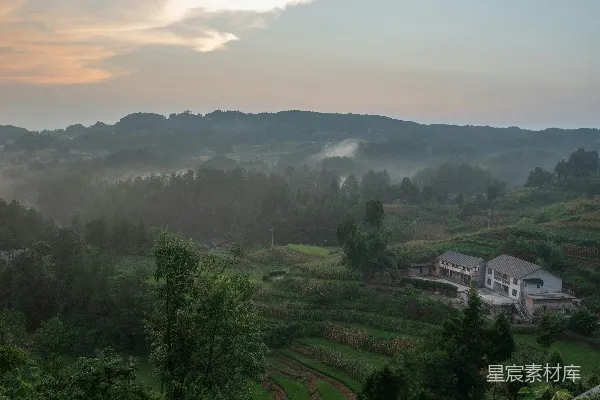 高清摄影 一片郁郁葱葱的山坡远景，远处有一座房子。