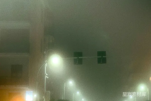 高清摄影 夜晚雾蒙蒙的城市街道，街道上有路灯。