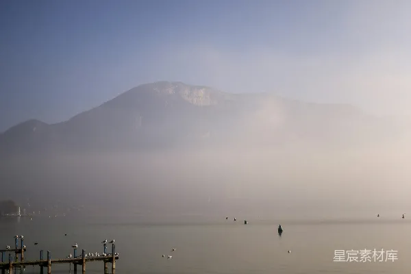 高清摄影 一片水域，岸边有码头，背景是山脉。