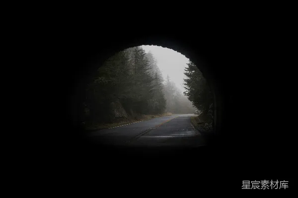 高清摄影 一条道路透过黑暗的隧道可见。