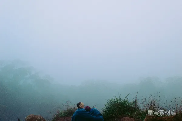 高清摄影 一个坐在雾中的岩石上的人