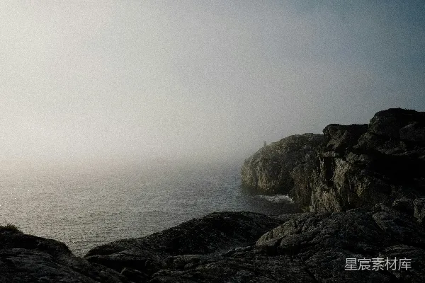 高清摄影 一个人站在岩石悬崖顶上，旁边是海洋。