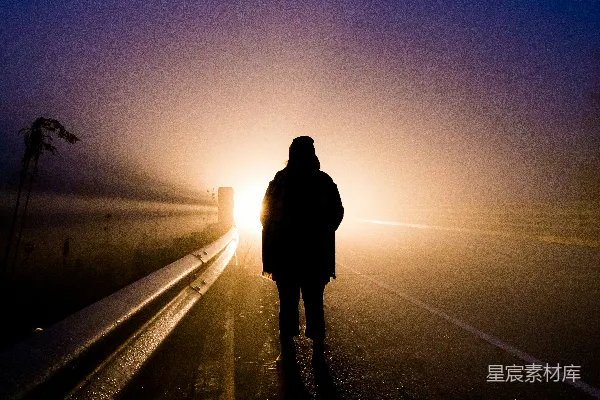 高清摄影 一个在雾中沿着道路行走的人