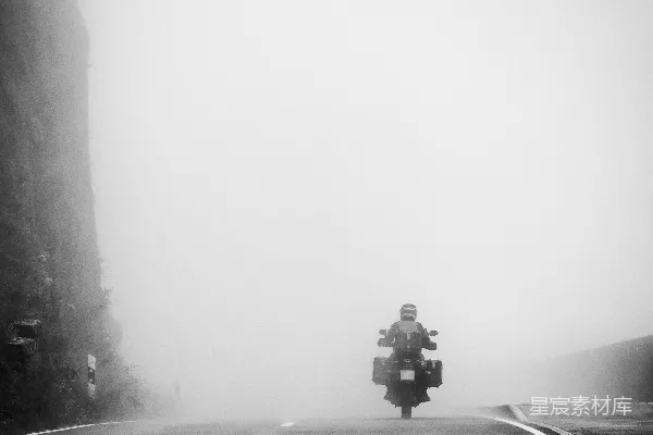高清摄影 在雾蒙蒙的路上骑摩托车的人