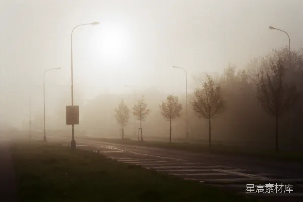 高清摄影 雾蒙蒙的街道上有路灯和路标。