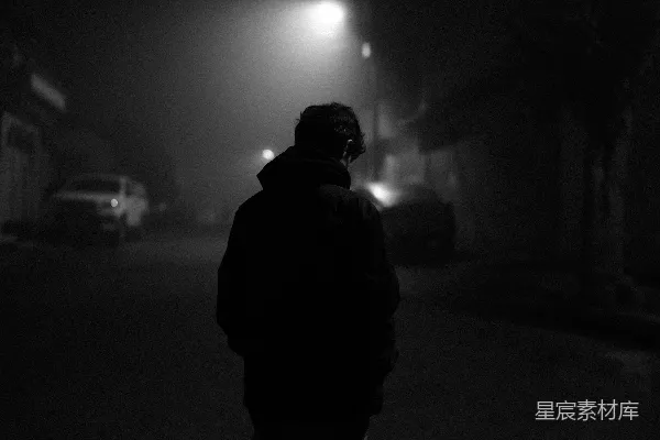 高清摄影 一个人在夜晚的雾气中走在街道上。