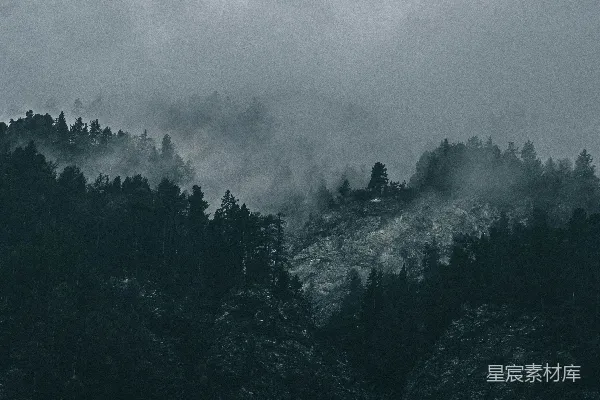 高清摄影 一张黑白照片，展示了一座山峰，山峰被云层覆盖。