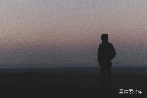 高清摄影 在日落时分，一个人站在山顶的剪影。
