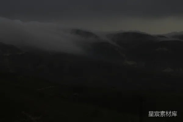 高清摄影 暮色中，雾霭缭绕的山脉被乌云笼罩。