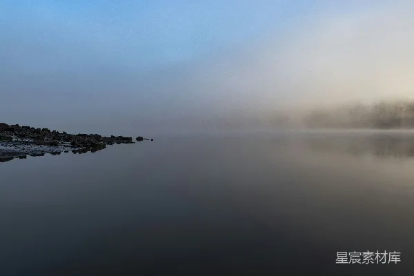 高清摄影 平静海面旁的黑色海滩岩石