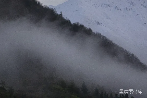高清摄影 一座山被雾笼罩，前景中有一座房子。