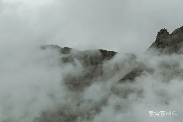 高清摄影 一座被雾笼罩的山丘，前景中有一根电线杆。